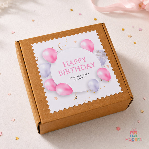 Little birthday hamper with personalized name decoration, birthday chocolate bar, and chocolate treats in a kraft gift box.