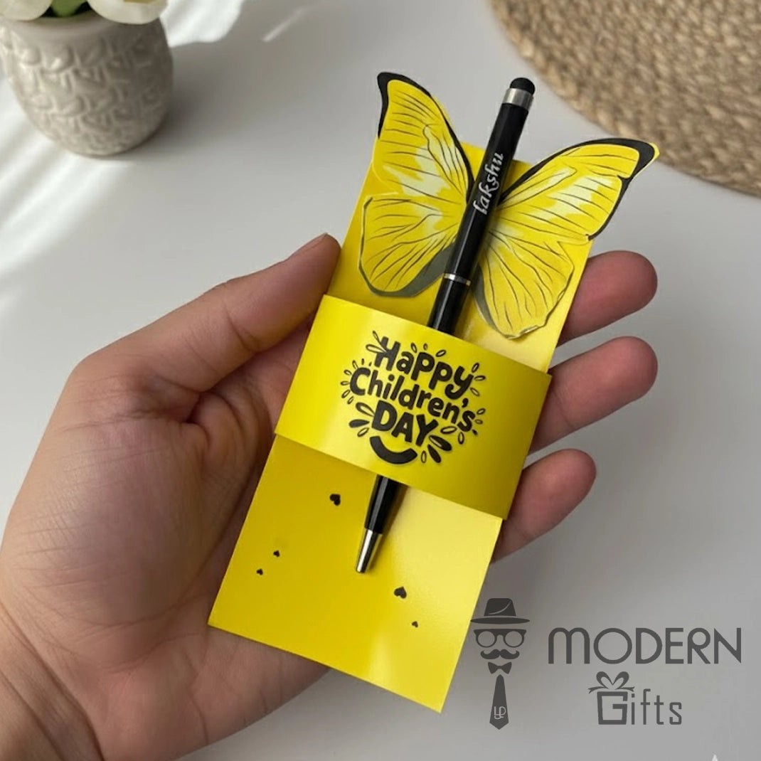 Yellow butterfly-shaped pen holder with a pen, held by a hand, on a white surface with 'Modern Gifts' branding.