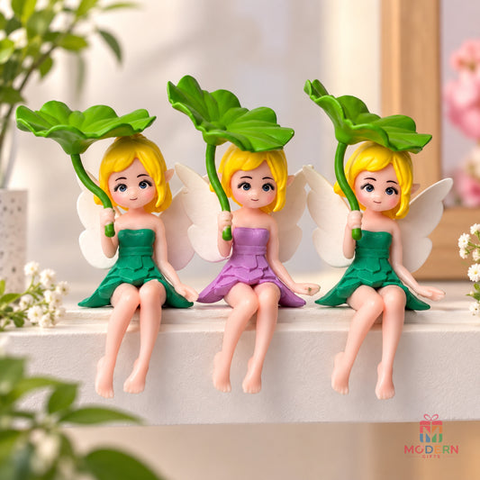 Set of three cute fairy miniature dolls with colorful dresses, white wings and green leafy umbrellas displayed on a shelf
