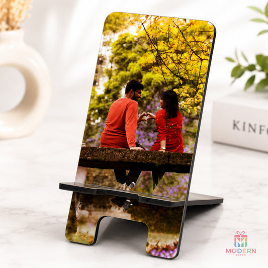 Personalized photo mobile stand displaying a couple photo on a desk.