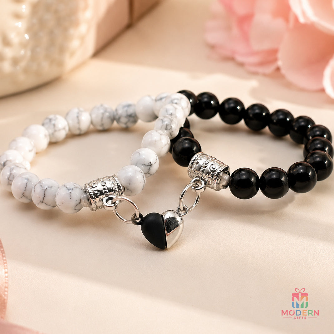 Matching couple bracelets with black and white beads and a connected heart design