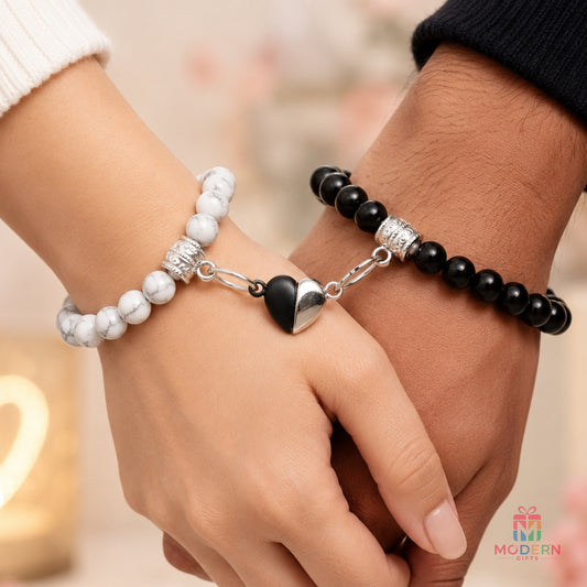 Matching couple bracelets with black and white beads and a connected heart design