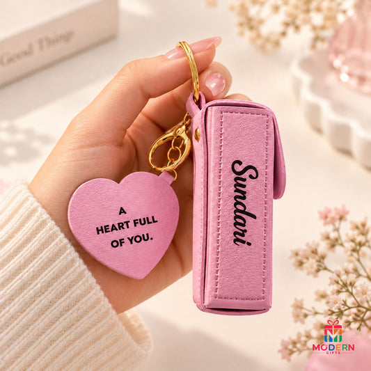 Customised pink lipstick pod keychain with golden button, heart charm and personalized name accessory.
